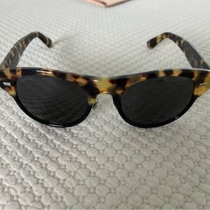 GUCCI sunglasses with tortoise shell finish and dark greenish/black lenses.